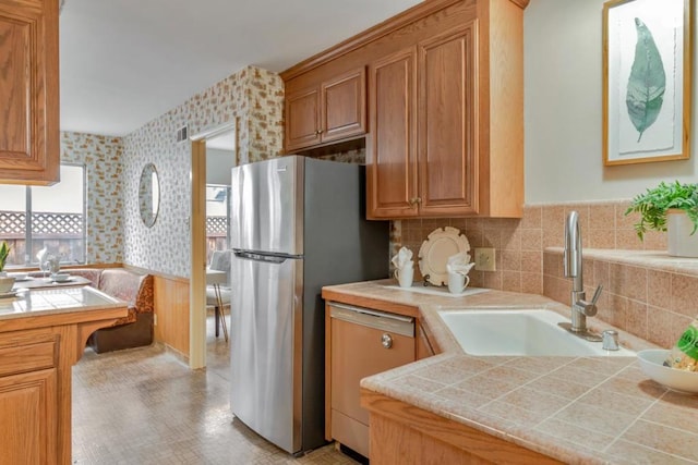 kitchen featuring appliances with stainless steel finishes, tile countertops, and sink