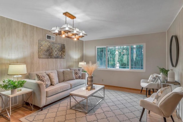 living room featuring a notable chandelier and light wood-type flooring