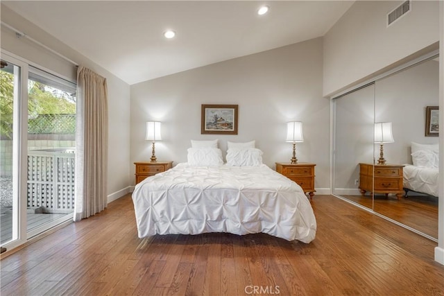 bedroom featuring a closet, vaulted ceiling, hardwood / wood-style floors, and access to outside