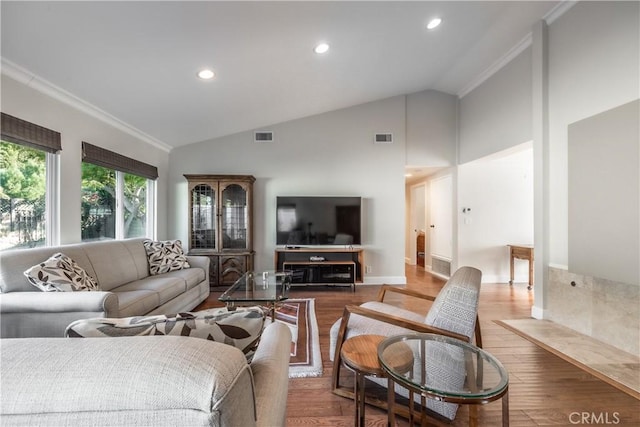 living room with hardwood / wood-style flooring, ornamental molding, and high vaulted ceiling