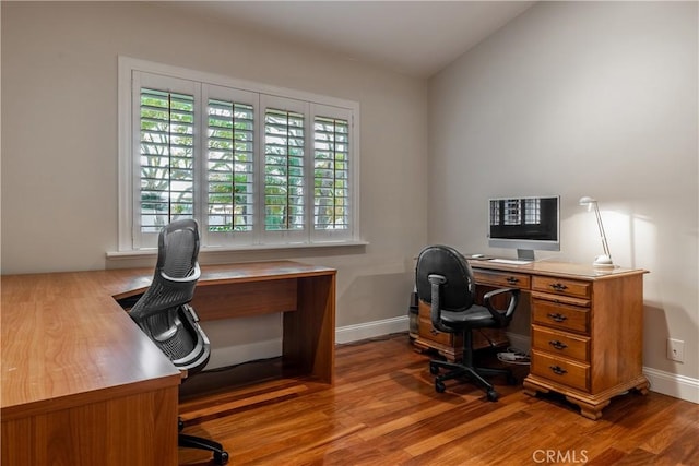 office area with hardwood / wood-style flooring and vaulted ceiling