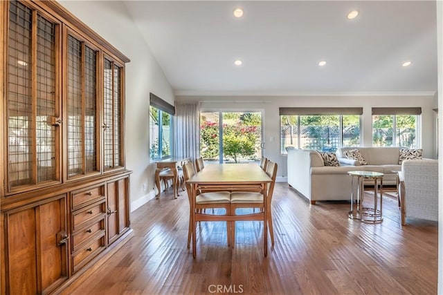 dining space featuring a wealth of natural light, wood-type flooring, and vaulted ceiling