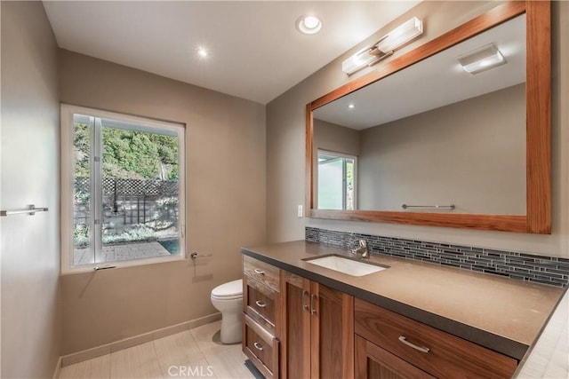 bathroom with tasteful backsplash, vanity, tile patterned flooring, and toilet