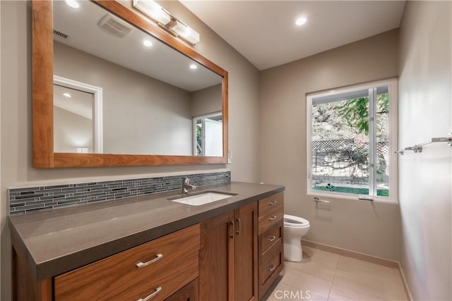 bathroom with tasteful backsplash, vanity, plenty of natural light, and toilet