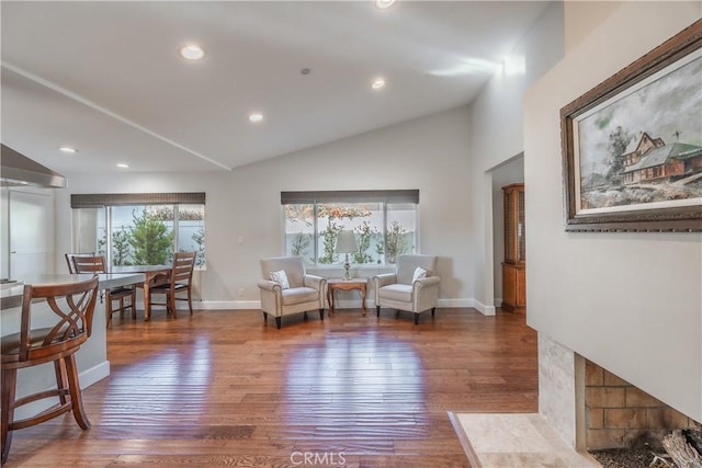 living area with lofted ceiling and hardwood / wood-style floors