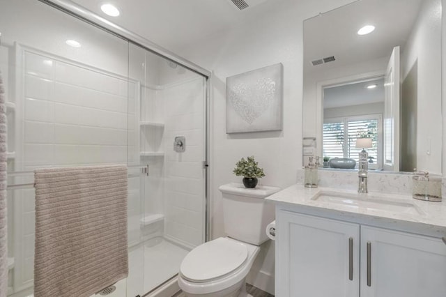 bathroom with vanity, toilet, and a shower with shower door