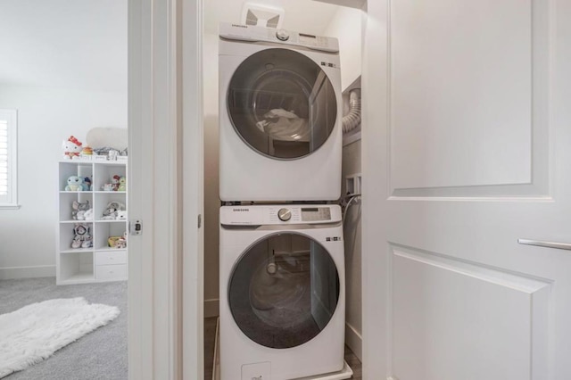 washroom featuring stacked washer and clothes dryer and carpet