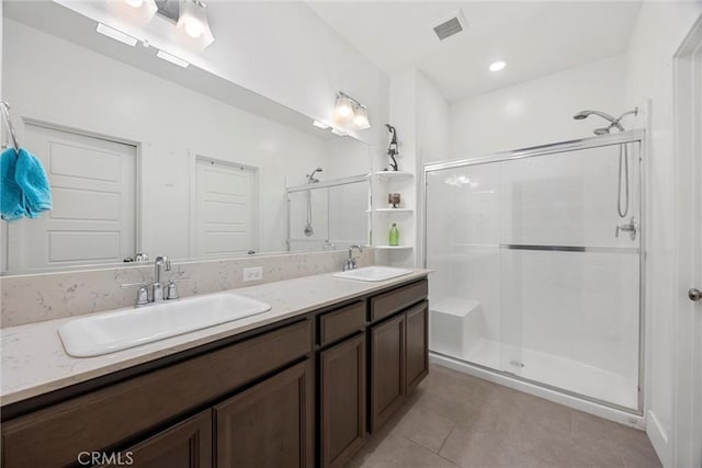 bathroom with an enclosed shower, vanity, and tile patterned flooring