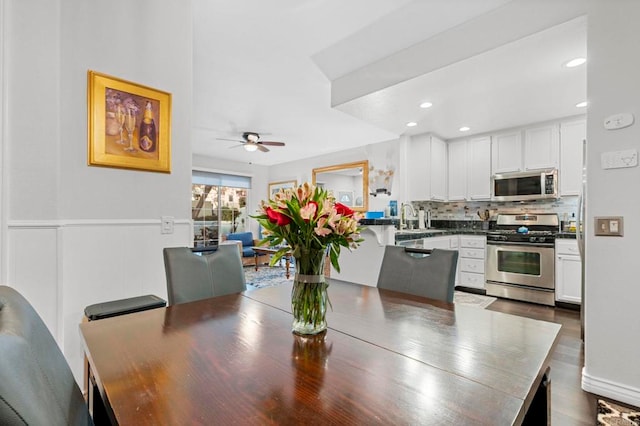 dining room with sink, dark hardwood / wood-style floors, and ceiling fan