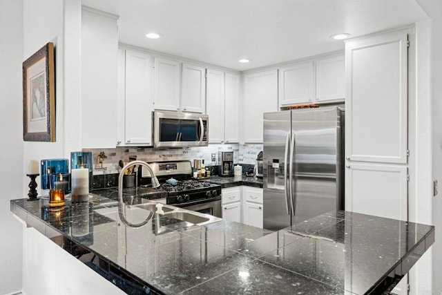 kitchen with white cabinetry, backsplash, and appliances with stainless steel finishes