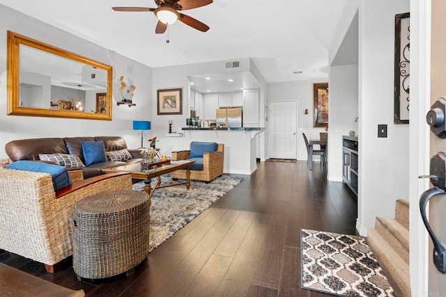 living room featuring dark wood-type flooring and ceiling fan