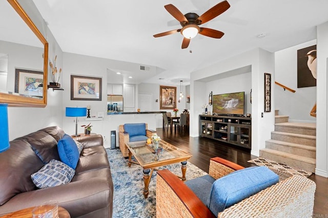 living room with dark wood-type flooring and ceiling fan