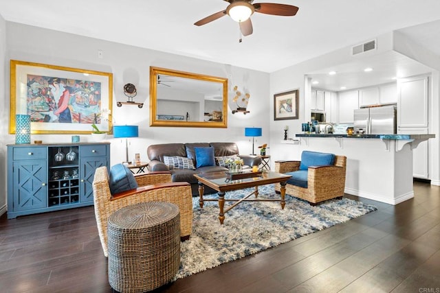 living room featuring dark wood-type flooring and ceiling fan