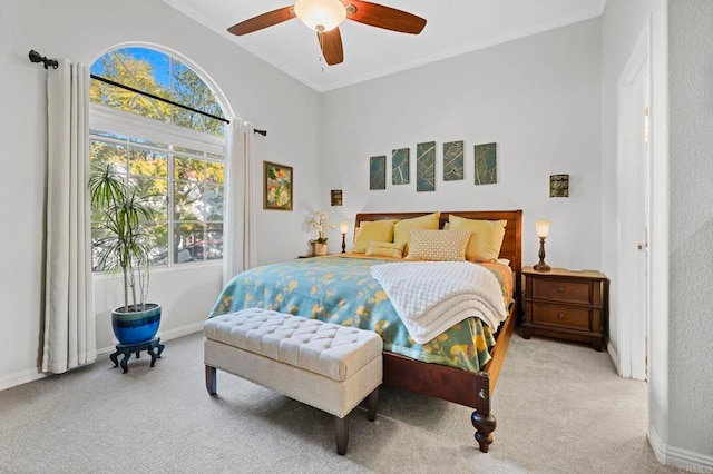 carpeted bedroom with ceiling fan and ornamental molding