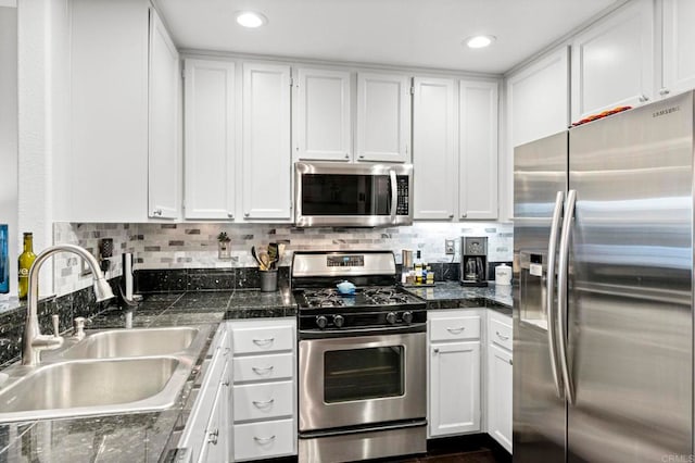 kitchen featuring white cabinetry, stainless steel appliances, sink, and decorative backsplash