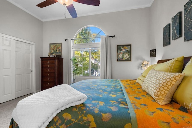 carpeted bedroom featuring ornamental molding, a closet, and ceiling fan