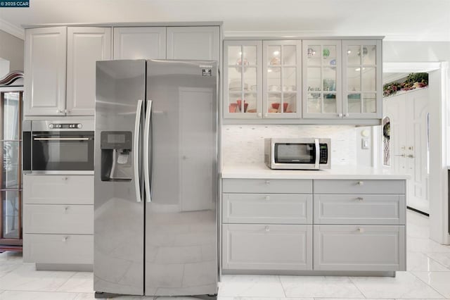 kitchen with tasteful backsplash, appliances with stainless steel finishes, and crown molding