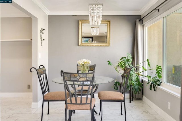 dining area with ornamental molding and an inviting chandelier