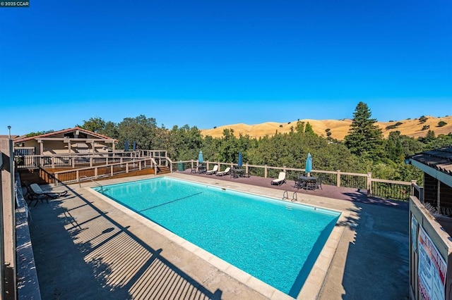 view of swimming pool featuring a mountain view and a patio