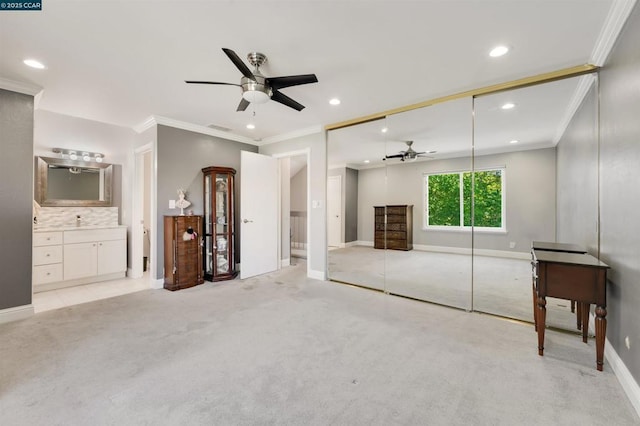 unfurnished living room with light carpet, crown molding, and ceiling fan