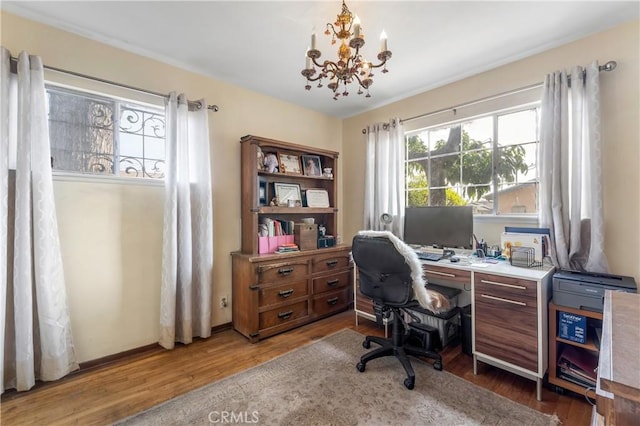 home office featuring hardwood / wood-style floors and a notable chandelier