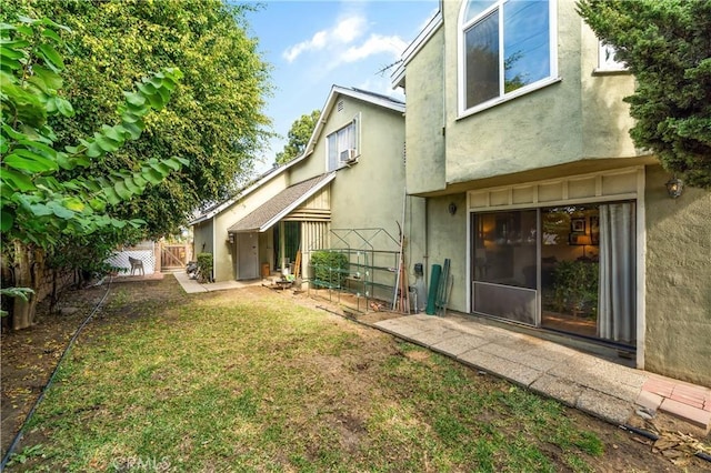 rear view of property with a yard and a patio area