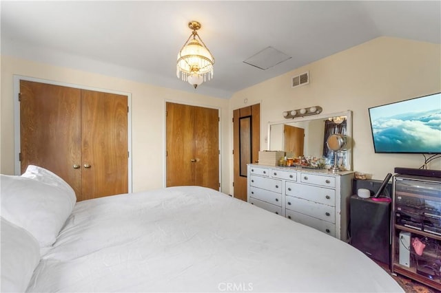 bedroom featuring multiple closets and vaulted ceiling