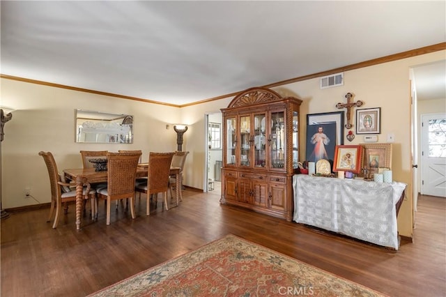 dining area featuring dark hardwood / wood-style flooring and ornamental molding