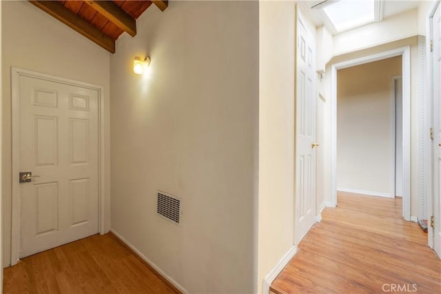 hallway featuring wood ceiling, vaulted ceiling with beams, and light wood-type flooring