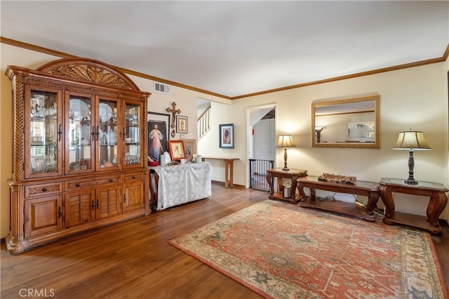 living area with wood-type flooring and crown molding