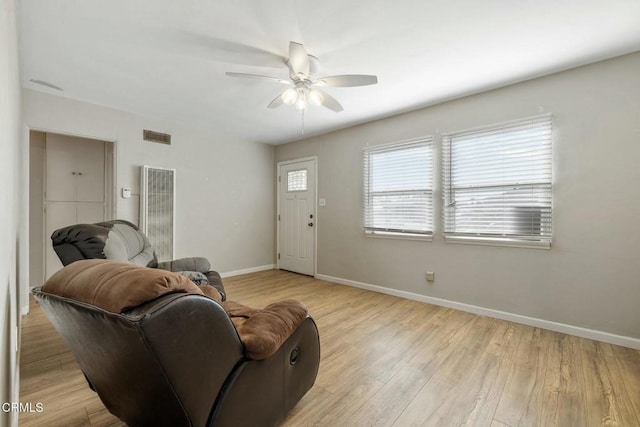 living room featuring ceiling fan and light hardwood / wood-style floors