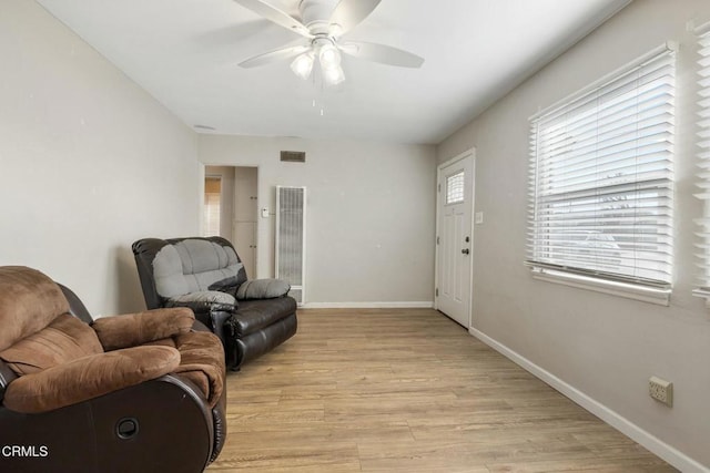 living room featuring ceiling fan and light hardwood / wood-style floors