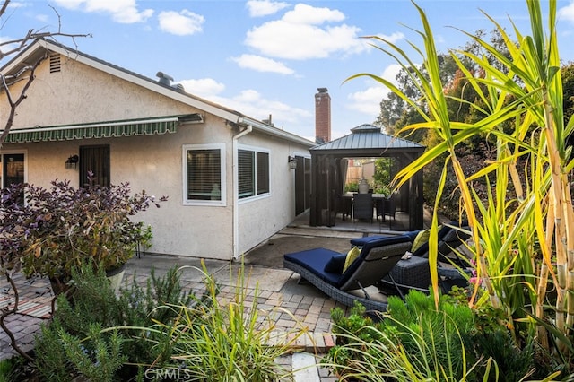 view of property exterior featuring a gazebo and a patio