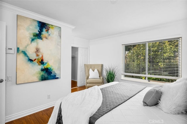 bedroom with crown molding, wood-type flooring, and a closet