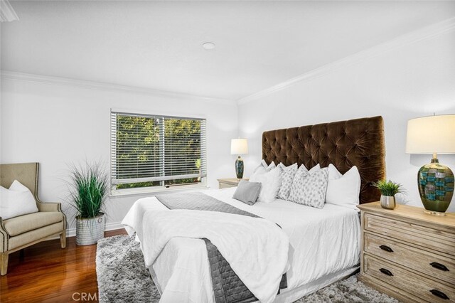 bedroom with crown molding and dark hardwood / wood-style floors