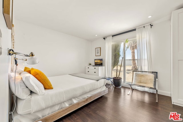 bedroom with dark hardwood / wood-style flooring