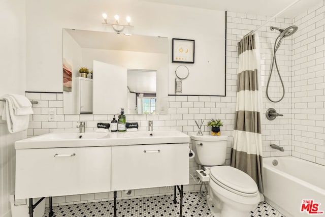 full bathroom with shower / bath combination with curtain, vanity, toilet, and tile walls