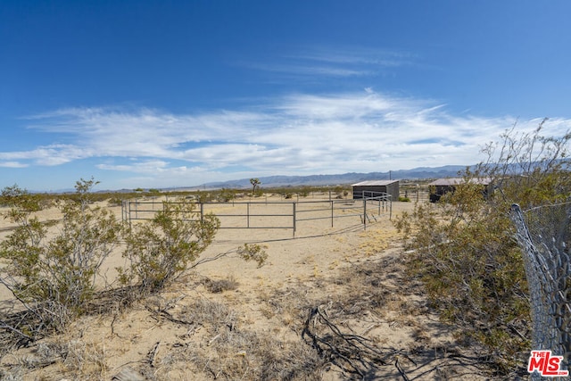 view of yard featuring an outbuilding, a mountain view, and a rural view