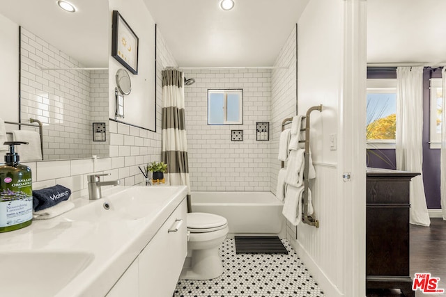 full bathroom featuring toilet, tile walls, vanity, shower / bath combo, and decorative backsplash