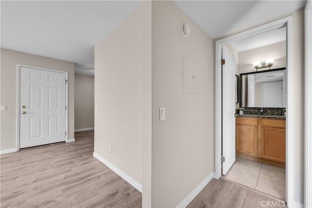 corridor with sink and light hardwood / wood-style floors