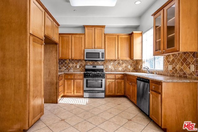 kitchen with sink, decorative backsplash, stainless steel appliances, and light tile patterned floors