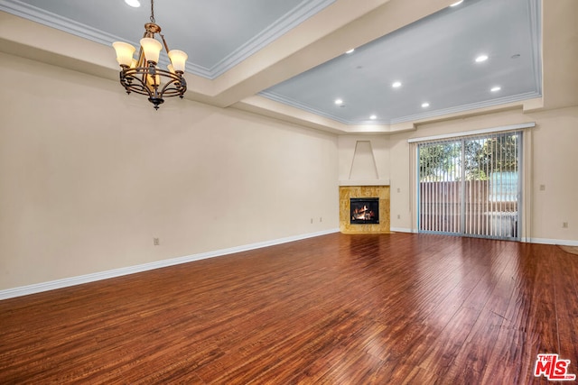 unfurnished living room with hardwood / wood-style floors, a high end fireplace, ornamental molding, a raised ceiling, and a chandelier