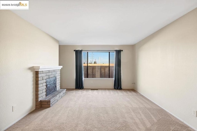 unfurnished living room featuring light carpet and a fireplace