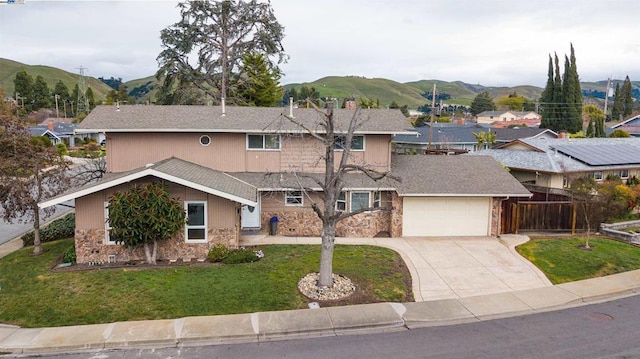 view of front of house featuring a garage, a mountain view, and a front lawn