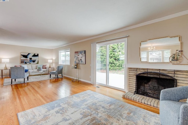 living room with a brick fireplace, wood-type flooring, and ornamental molding