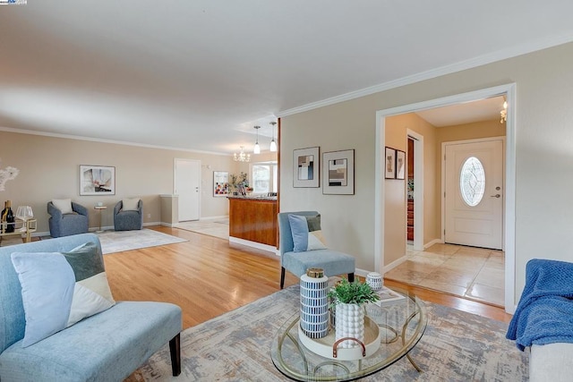 living room featuring crown molding, light hardwood / wood-style flooring, and a chandelier