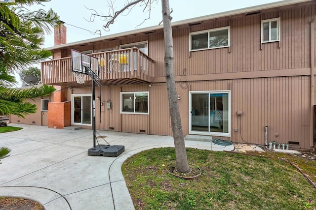 back of house with a balcony, a yard, and a patio area