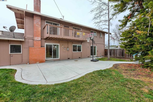 rear view of house featuring a yard, a patio area, and a balcony