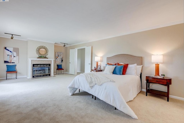 bedroom with light carpet, crown molding, and rail lighting