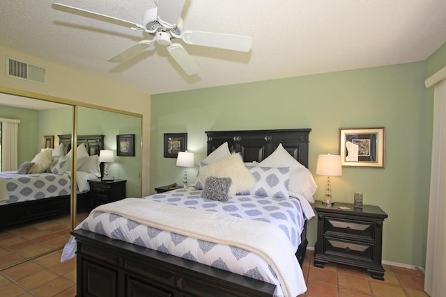 bedroom with a closet, ceiling fan, and light tile patterned flooring